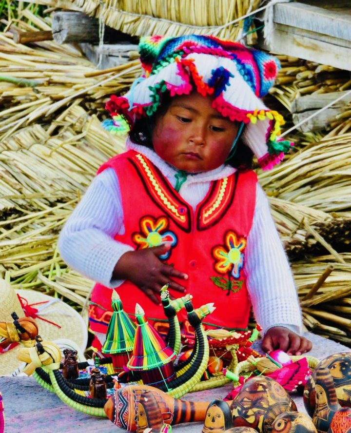 Little kid with traditional clothing at Islas Uros in Puno Peru, Travel blog Peru