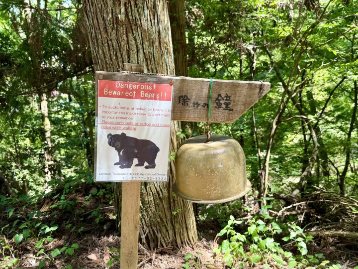 Bear warning sign with bell along the Shiroyama Park walk in Takayama