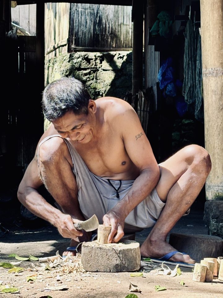 Man working with wood in Bena Traditional Village