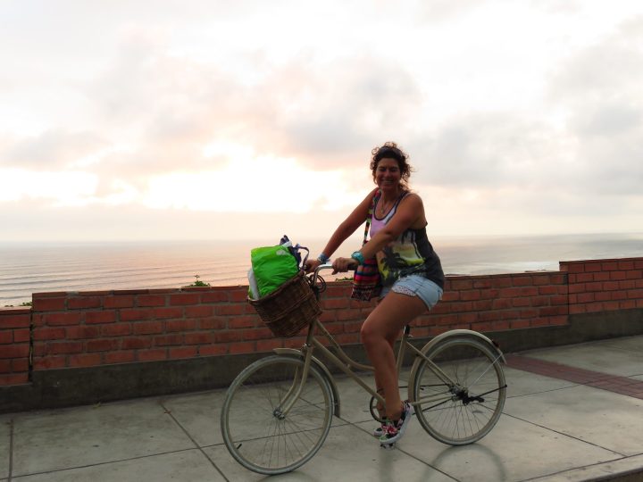 Woman cycling along the Malecón in Miraflores Lima with the Pacific Ocean in the background